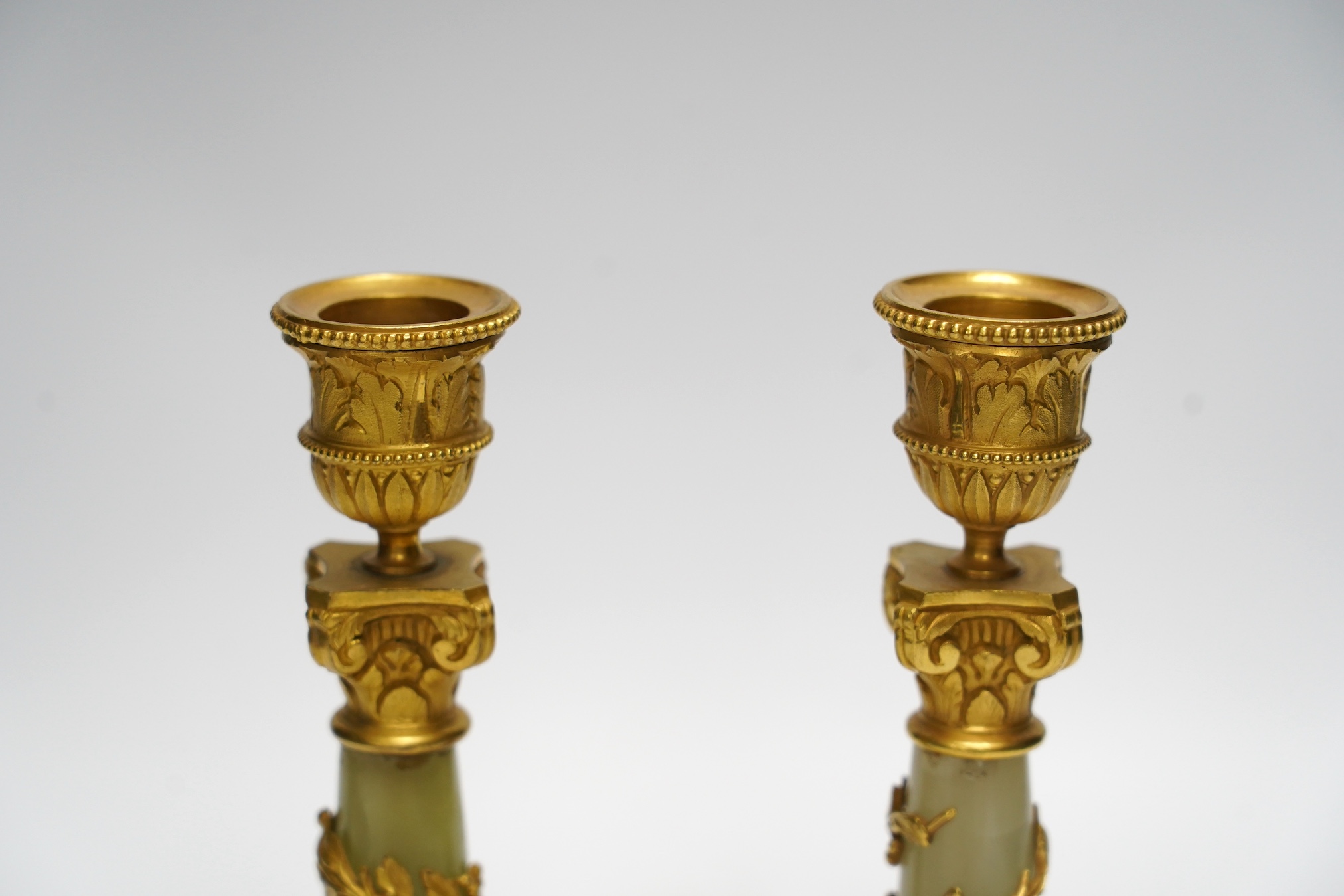 A pair of early 20th century French ormolu mounted onyx candlesticks, 20cm high